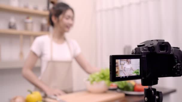 Ασιατικές γυναίκα blogger χρησιμοποιώντας κάμερα εγγραφής πώς να κάνει σαλάτα υγιεινά τρόφιμα βίντεο για τον συνδρομητή, θηλυκή χρήση βιολογικά λαχανικά προετοιμασία σαλάτα για κατάλληλο σώμα στο σπίτι. Έννοια της υγιεινής διατροφής. - Πλάνα, βίντεο
