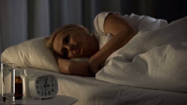 Mature woman spending sleepless night at rehabilitation center, feeling pain - Valokuva, kuva