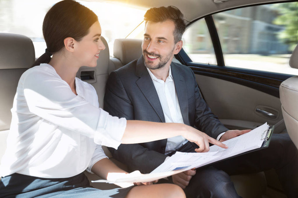Business partners working with documents in car - Foto, Imagen