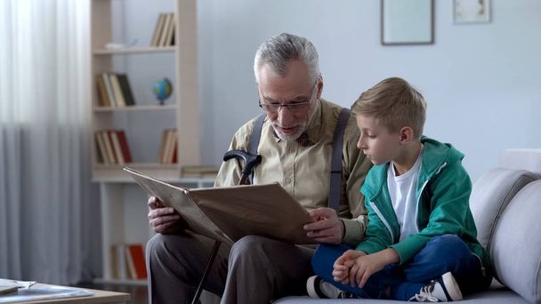 Old man reading book to grandson, giving experience to younger generation - Φωτογραφία, εικόνα