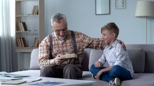 Grandson giving present to grandfather, attention and care for loved ones - Foto, Imagen
