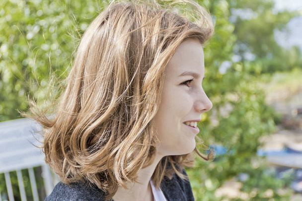 Profile of blond girl fourteen years old in summer background - Fotoğraf, Görsel