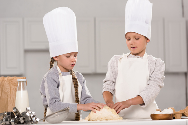 adorable kids preparing dough for cookies at table in kitchen - Valokuva, kuva