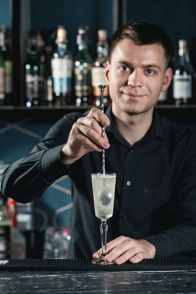 barman faisant français 75 Cocktail. Mélanger les ingrédients dans un verre. Bar sur fond
 - Photo, image