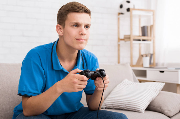 Adolescente niño jugando juegos en línea con joystick en las manos
 - Foto, Imagen