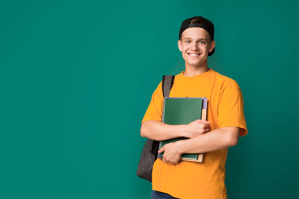 Happy student with books and backpack over background - Фото, изображение