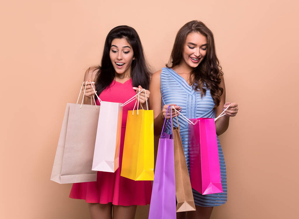 Happy podekscytowany kobiet patrząc do torby na zakupy - Zdjęcie, obraz