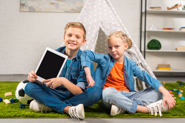 happy little kids showing digital tablet with blank screen near tent at home - Foto, afbeelding