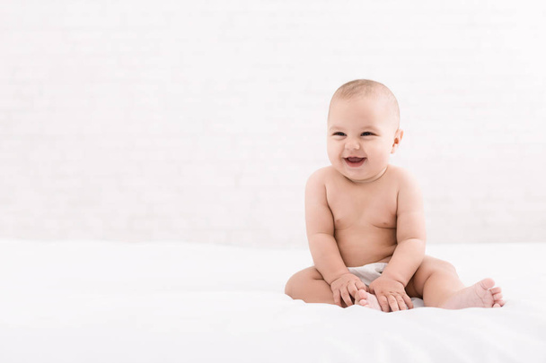 Cute baby sitting on white background, copy space - Foto, Imagen