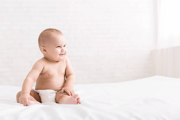 Cute baby sitting on white background, copy space - Foto, Imagem