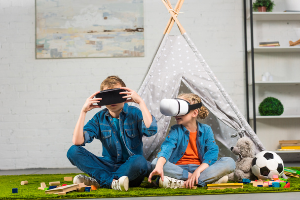 brother and sister using virtual reality headsets near wigwam at home - Φωτογραφία, εικόνα