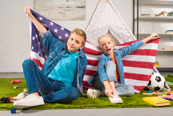 adorable kids showing national american flag near wigwam, independence day concept  - Fotografie, Obrázek