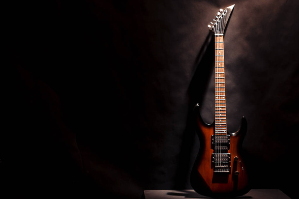 Red electric guitar on a dark background. - Fotó, kép