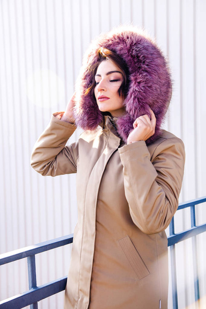 Mulher da moda. Menina bonita em uma jaqueta quente goza do sol de inverno
. - Foto, Imagem