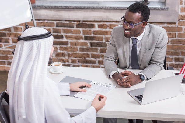 Арабский бизнесмен подписывает контракт на офисном столе
   - Фото, изображение