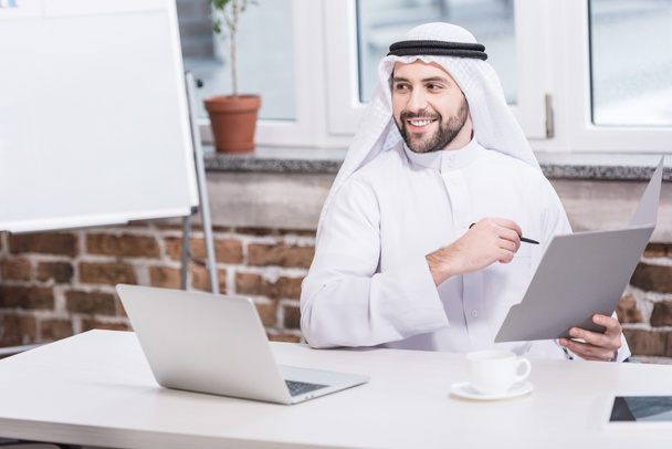 Аравії бізнесмен, проведення папку і перо в офісі  - Фото, зображення