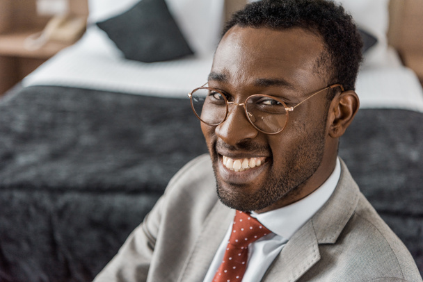 sonriente hombre de negocios afroamericano en gafas y ropa formal
 - Foto, Imagen