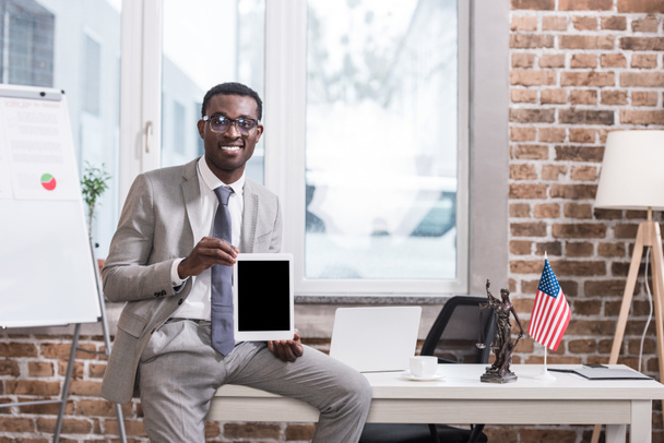 Afrikkalainen amerikkalainen liikemies osoittaa digitaalinen tabletti tyhjällä näytöllä
 - Valokuva, kuva