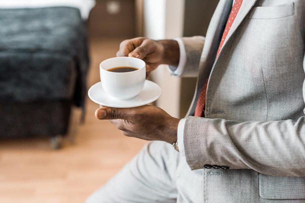 cropped view of elegant african american man holding cup of coffee  - Foto, imagen