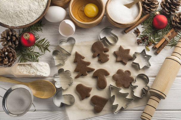 Decorative New Year bakery with molds and ingredients on a wooden white background. Top view. - Foto, afbeelding