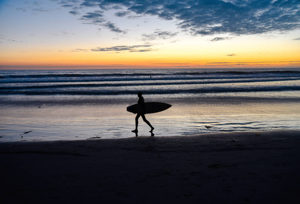 Surfer silhouette carrying a surfboard - Zdjęcie, obraz