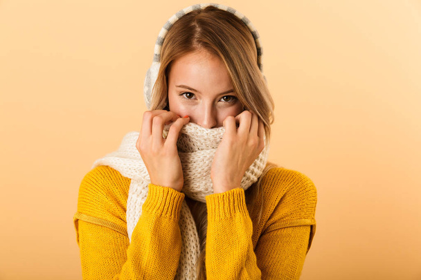 Photo of a happy woman wearing scarf isolated over yellow wall background. - 写真・画像
