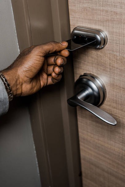 cropped view of african american man opening door with electronic key card in hotel - Photo, Image