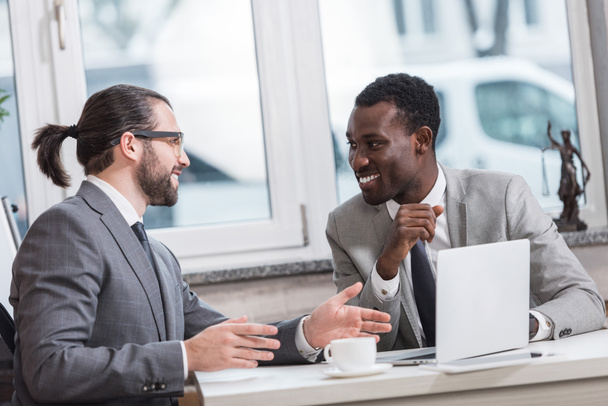 улыбающиеся многонациональные бизнесмены, встречающиеся в офисе
 - Фото, изображение