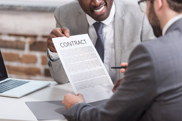 cropped view of african american businessman showing contract to partner - Photo, Image