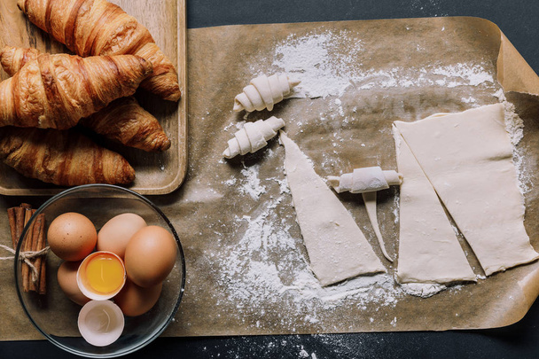 Backpapier mit Teig für Croissants, Eier und Zimt auf der Oberfläche - Foto, Bild