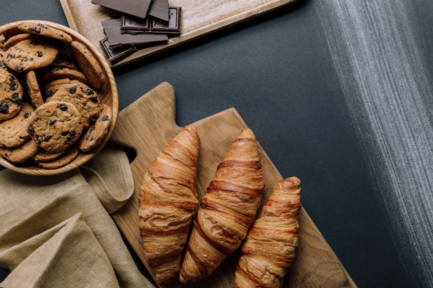ylhäältä näkymä croissantit, suklaa ja evästeet musta pöytä
 - Valokuva, kuva