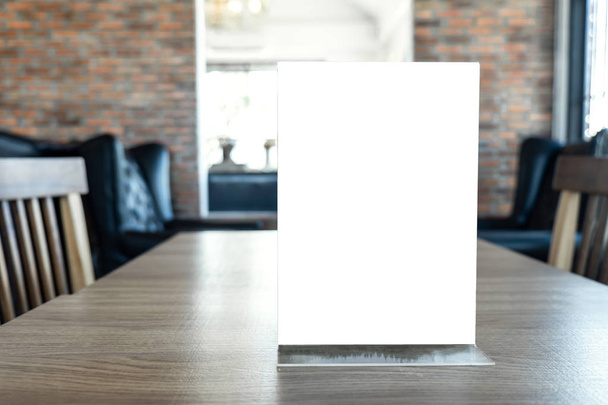 Schermo bianco modellare cornice del menu in piedi su tavolo di legno in caffè e ristorante sfondo
. - Foto, immagini
