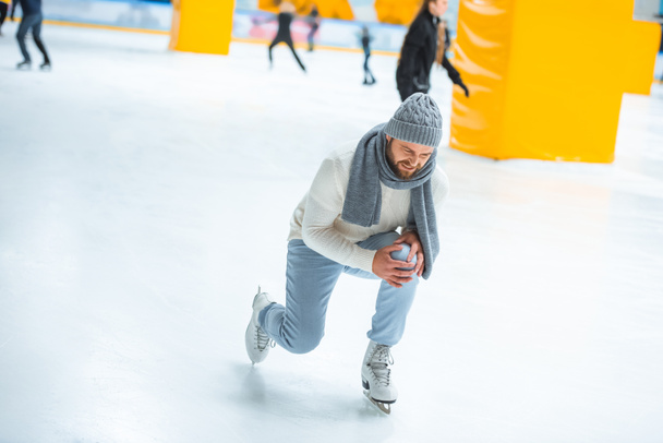 man injured knee while skated on ice rink - Photo, Image