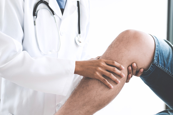Arzt untersucht Patienten mit Knieproblemen, um die Ursache der Krankheit festzustellen. - Foto, Bild