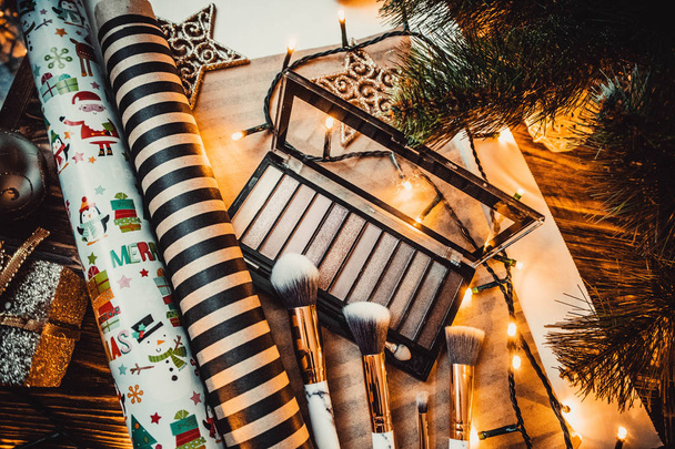 アイシャドウはクリスマスのおもちゃとブラシで木の茶色の背景 - 写真・画像