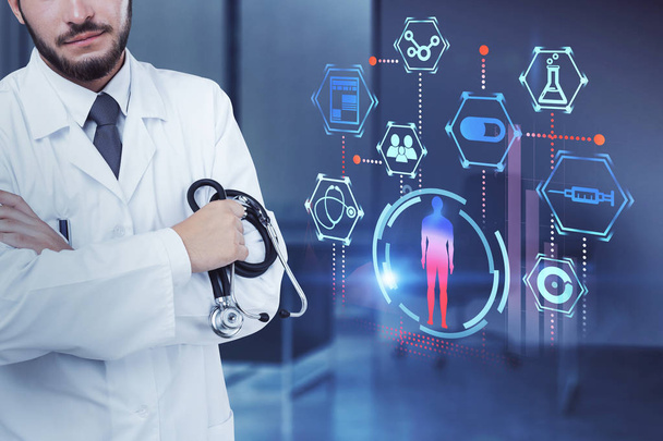 Unrecognizable confident man doctor standing with crossed arms holding a stethoscope in his office next to medical interface of man in hud and medical icons. Double exposure - Photo, image