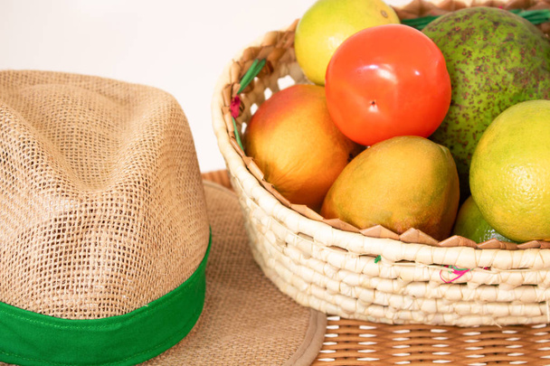 テーブルの上の果物やわら帽子のバスケット。農業の概念  - 写真・画像