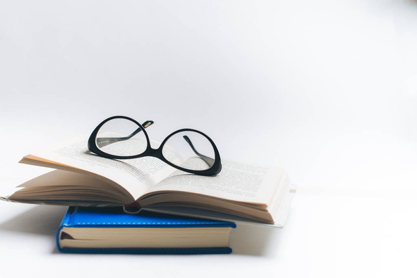 Jegyzetfüzet-val szemüveg és toll, könyv, szemüveg, szemüveg, foglaljon a csésze teát, szemüveg és toll, dolgozó kék notebook notebook írni - Fotó, kép
