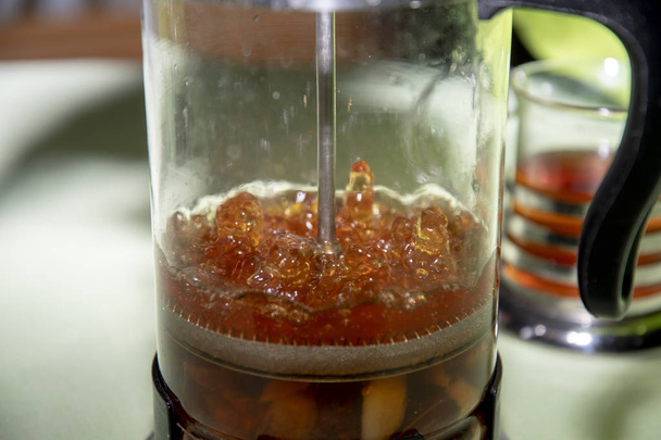 бульбашка гарячої чайної води готується в скляному горщику
 - Фото, зображення