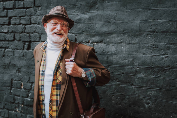Stylish old man in hat is walking outdoor - Valokuva, kuva