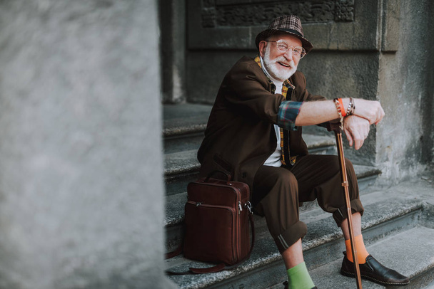 Senior man sitting on steps in the city - 写真・画像