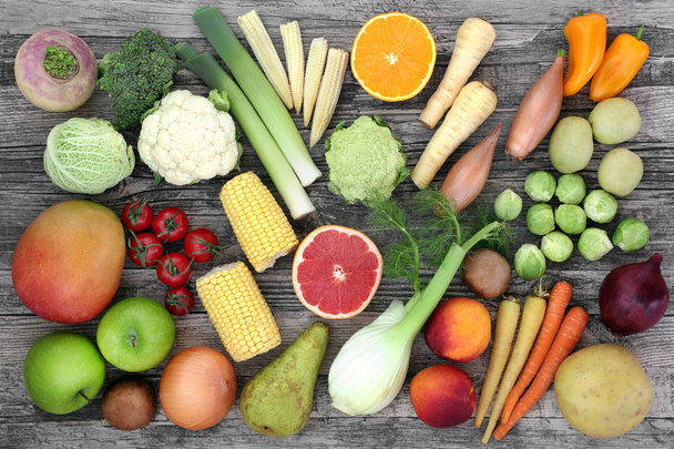 High fibre health food concept with fresh vegetables and fruit. Foods with antioxidants, carbohydrates, anthocyanins, vitamins and minerals. Top view on rustic wood background. - Photo, Image
