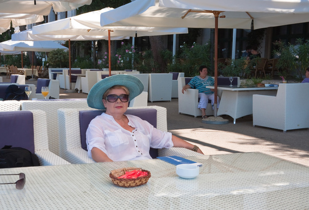 The woman at the table of street cafes. Hotel "Neptun-Istra". Bi - Photo, Image