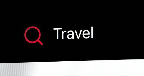 Λέξη Travel γραμμένο στη γραμμή αναζήτησης. Κλείνω πάνω θέα του μια οθόνη υπολογιστή - Φωτογραφία, εικόνα