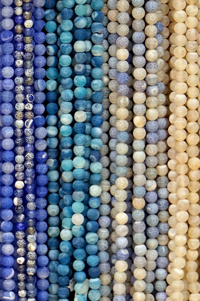bunte Perlen Hintergrund. Hintergrundmuster aus bunten Natursteinperlen. Perlenkette in verschiedenen Farben. bunte Perlenketten. Kunsthandwerk für Frauen in Mode - Foto, Bild