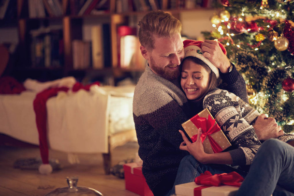smiling couple hugging by Christmas tree - Foto, Imagen