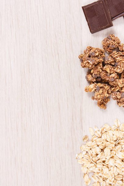 Oat flakes, granola and chocolate containing iron and dietary fiber, healthy snack or dessert concept, copy space for text or inscription - Fotoğraf, Görsel