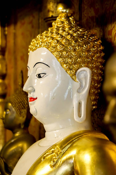 Κινηματογράφηση σε πρώτο πλάνο και πλευρά Δες αρχαία χρυσό άγαλμα του Βούδα της Βιρμανίας τέχνης στο ιερό στο Wat Phra ότι Hariphunchai το Rarin Thialand. - Φωτογραφία, εικόνα