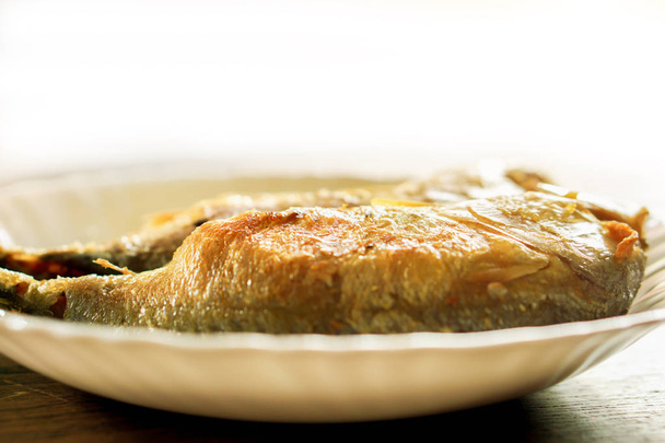 Closeup mackerels beyaz seramik tabak ve doğal güneş ışık arka plan ile ahşap masa kızarmış. Fried mackerels Tayland yemek ve Tay karides yemek için popüler chili sos (Nam Phrik Kapi yapıştırın) - Fotoğraf, Görsel