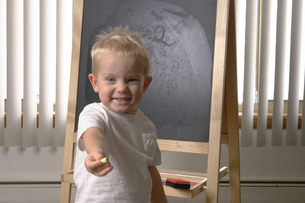 Cute little boy (toddler, two years old). Drawing on the chalkboard. Early childhood education to children concept.  Kindergarten, pre-primary, nursery school. - Photo, Image